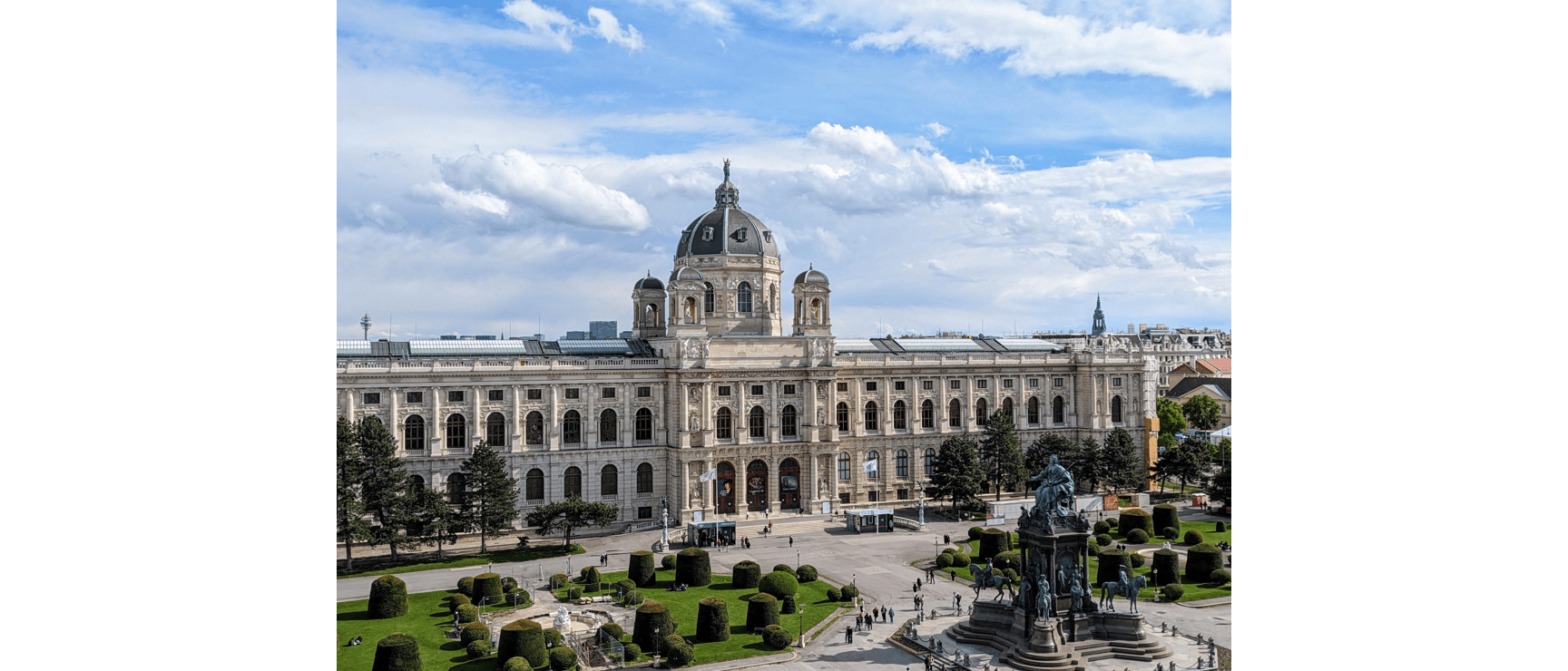 Kunsthistorisches Museum Vienna with dome, Maria Theresa Monument and manicured park in foreground.