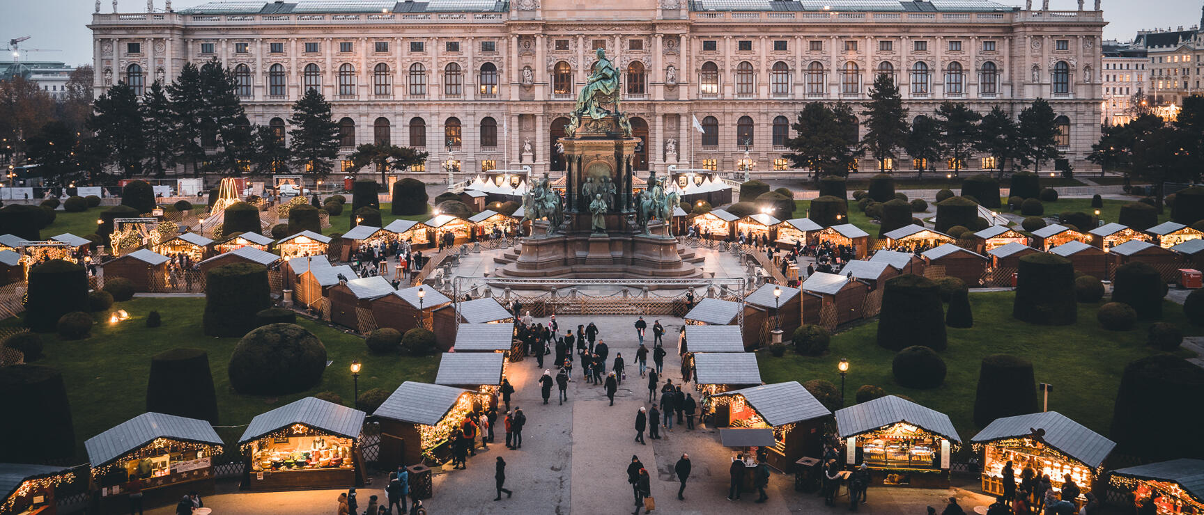 Christkindl market at Vienna's Maria Theresa Square, illuminated, with the Art History Museum in the background.