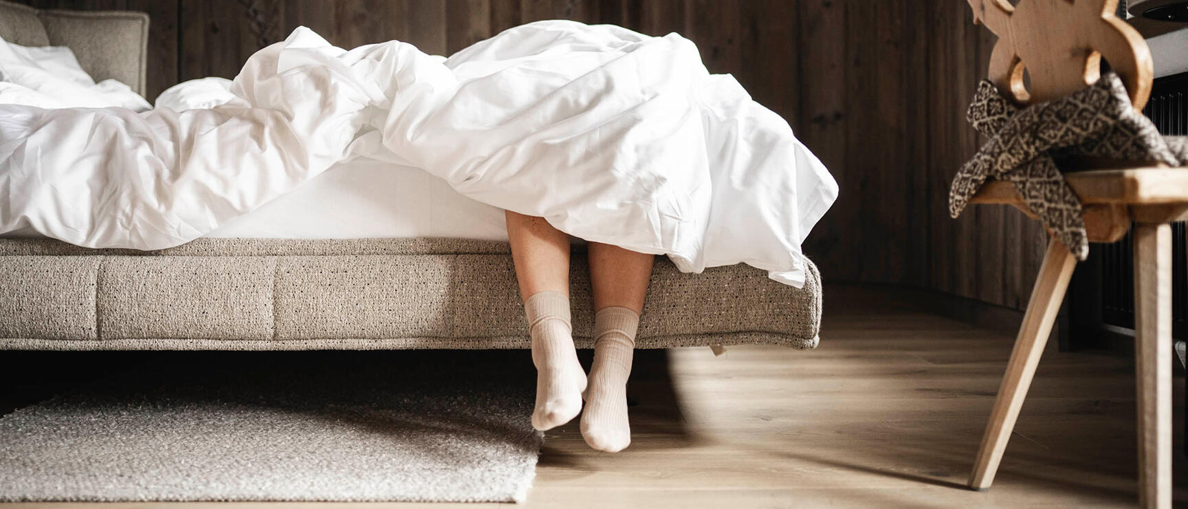 Person am Bett mit Holzstuhl neues Orgänic Top Komfortzimmer Nord