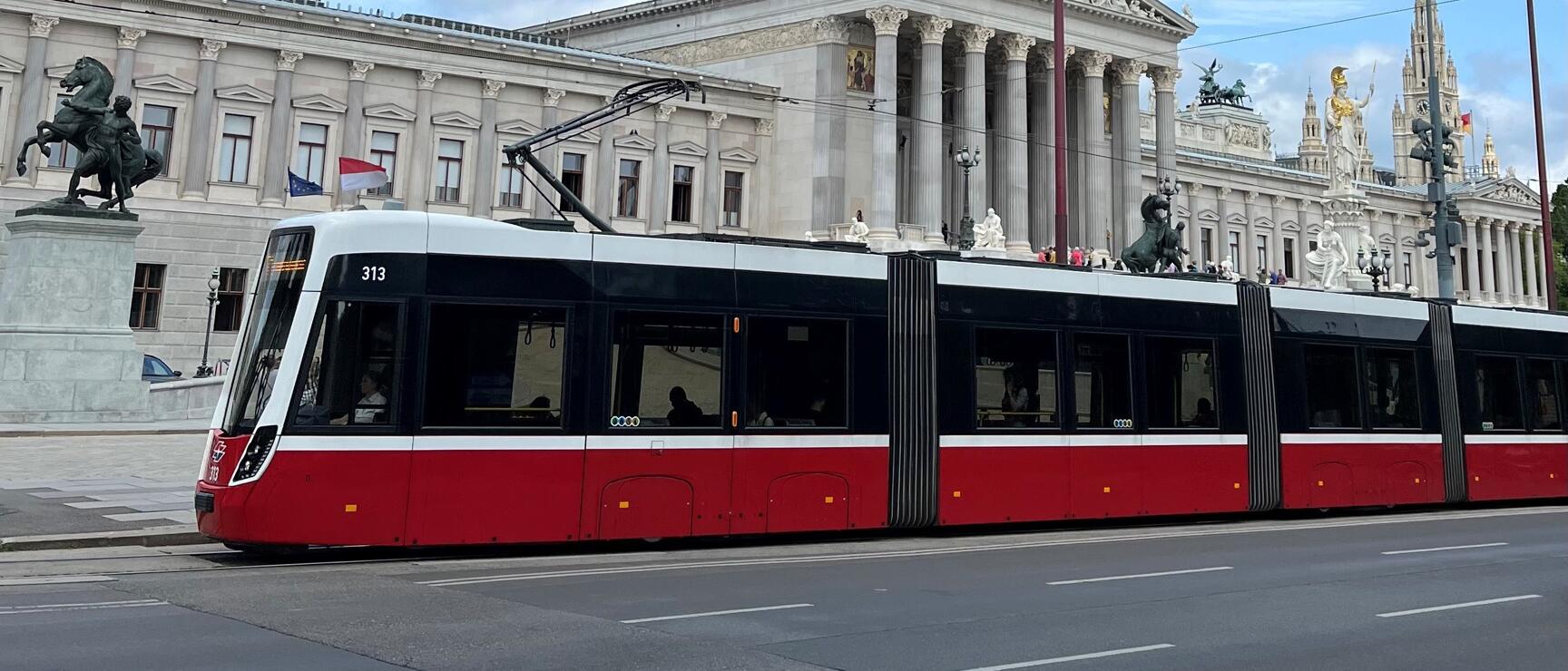 Red tram on Ringstraße in front of Austrian Parliament, Vienna.