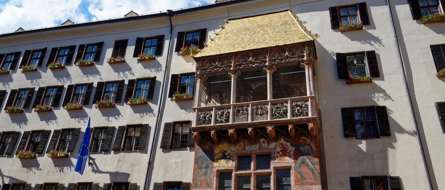 Goldenes Dachl in Innsbruck mit vergoldetem Erker, Fresken und EU-Flagge an der Fassade.