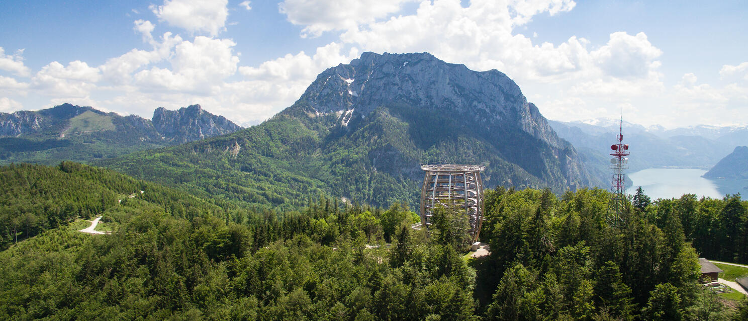 Wooden viewing tower in the forest, Traunstein mountain and Traunsee lake behind, Salzkammergut region.