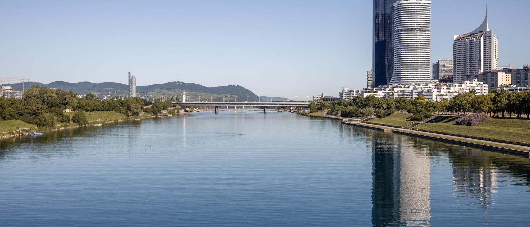 Panorama Aufnahme vom ruhendem Gewässer der Donauinsel mit Hochhäuser im Hintergrund