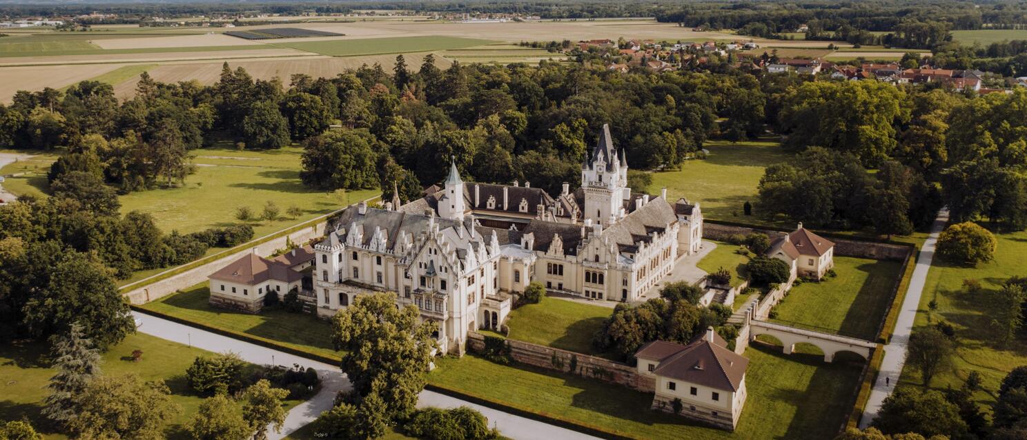 Aerial view of Grafenegg Castle with gardens, surrounded by fields and forests, Lower Austria.