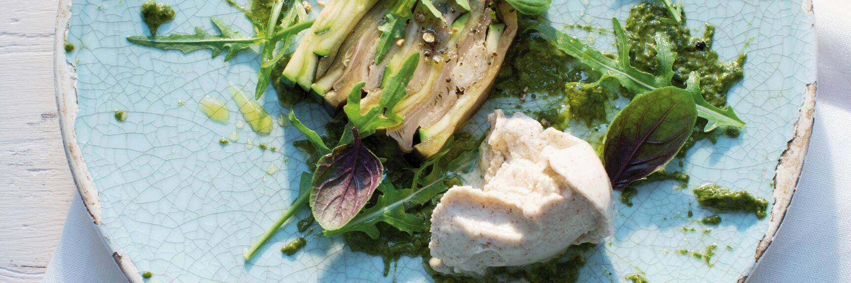 Grilled vegetables with pesto, rocket and purple basil leaves on light blue ceramic plate