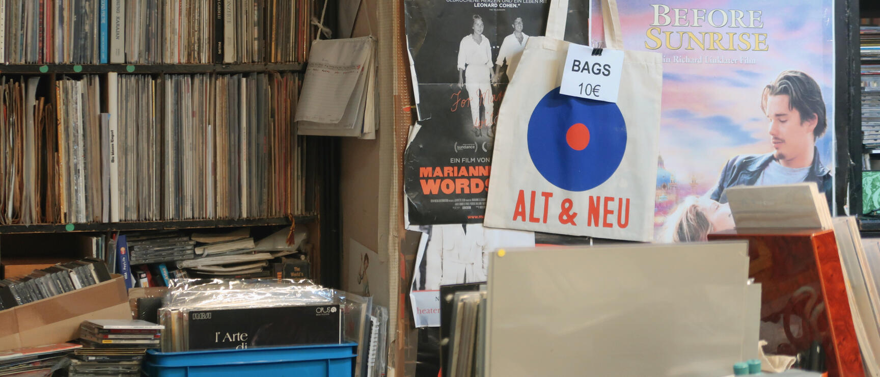 Record shop "Alt & Neu" with vinyl records, canvas tote bag (€10) and "Before Sunrise" film poster on the wall.