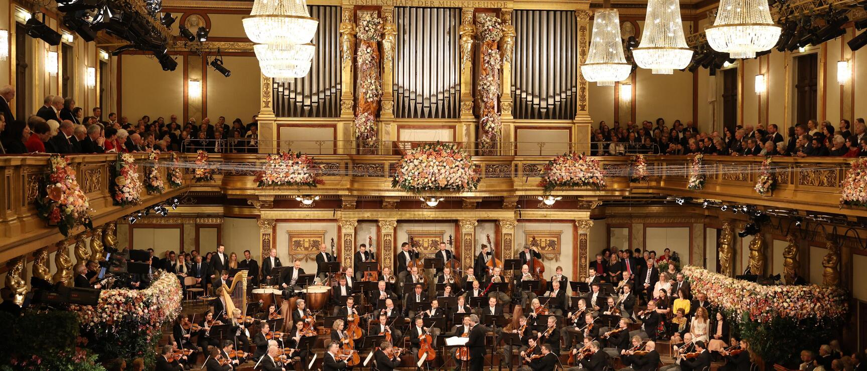Orchestra in the Golden Hall of Vienna Music Association, decorated with flowers, chandeliers and organ.