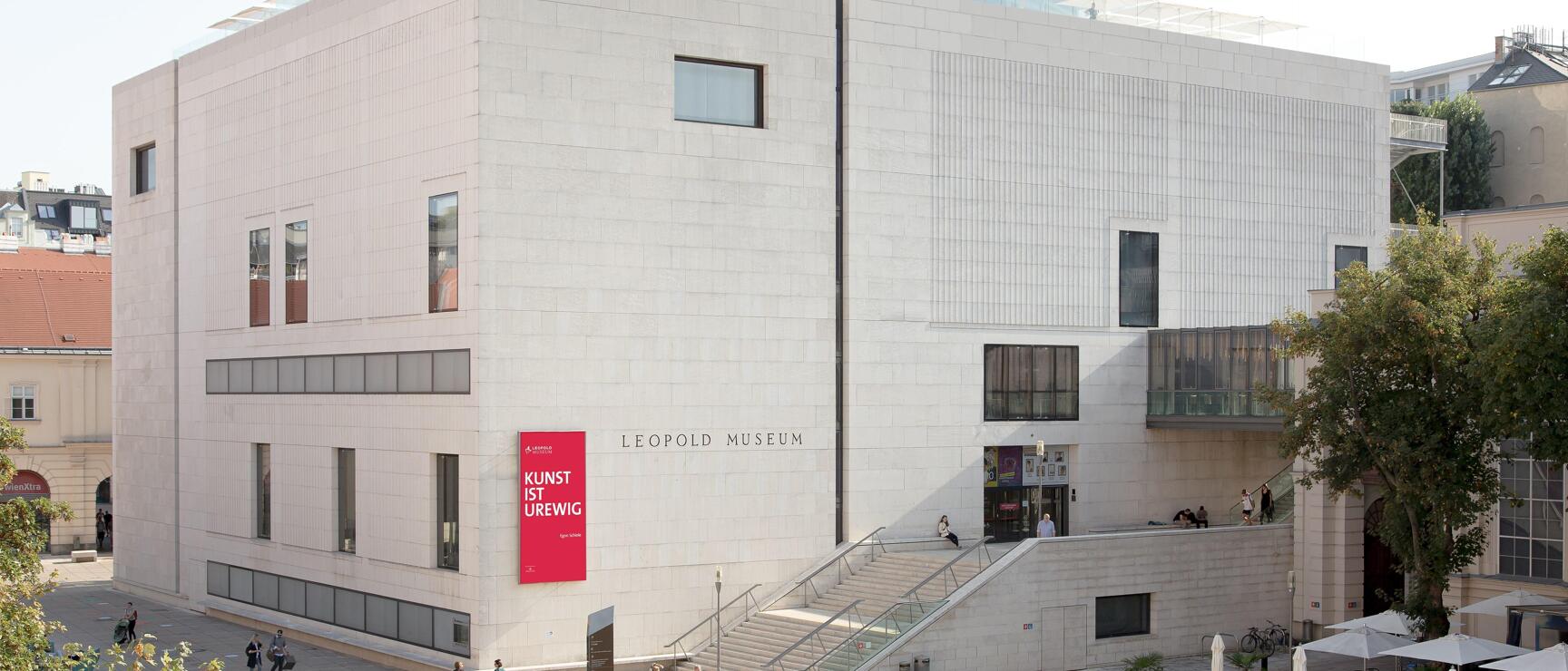 Exterior view of Leopold Museum in Vienna's MuseumsQuartier, visitors in forecourt with water basin.