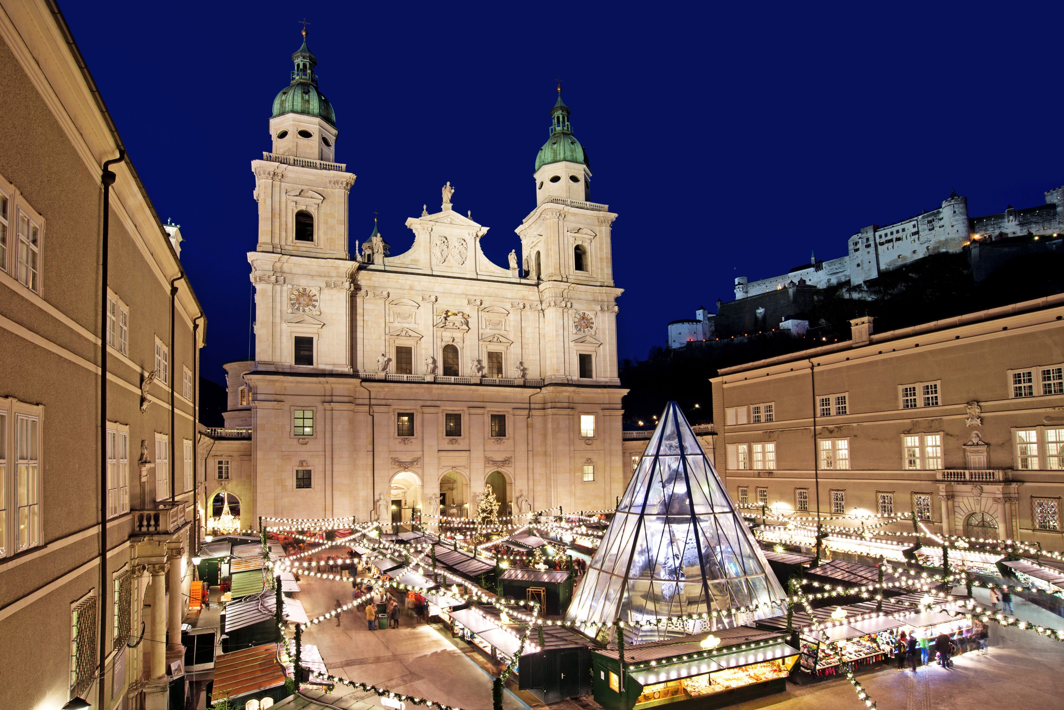 Salzburg Christkindlmarkt on Domplatz with Salzburg Cathedral, Hohensalzburg Fortress, and illuminated market stalls