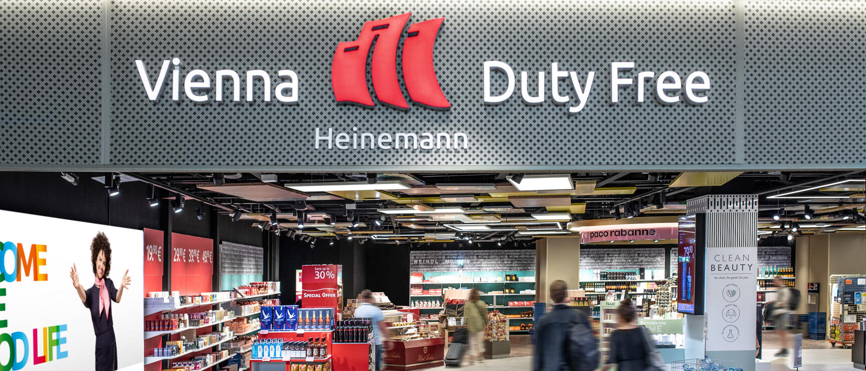 Entrance of Vienna Duty Free Heinemann shop at Vienna Airport, people entering the store.