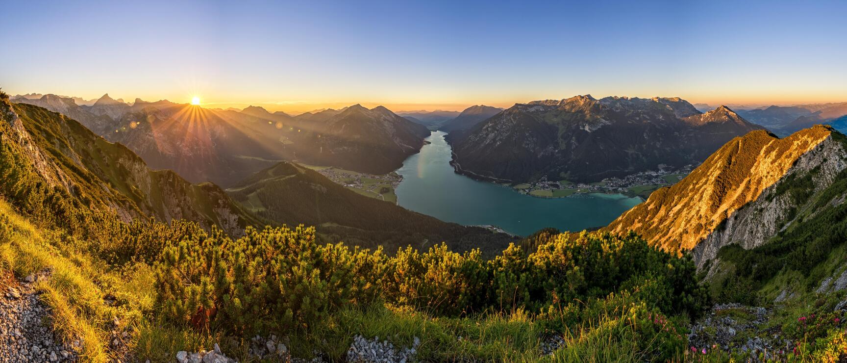 Panoramic view of Lake Achensee at sunrise, surrounded by mountains and alpine villages, Tyrol.