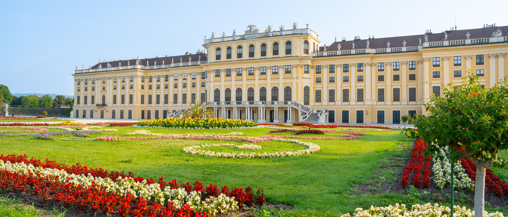Schönbrunn Palace Vienna with blooming flower garden in red and white in foreground
