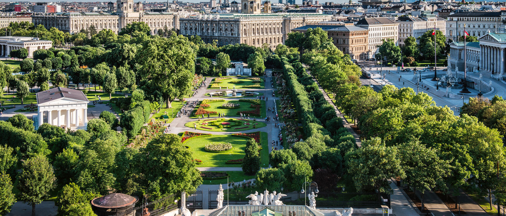 Aerial view of Vienna's Volksgarten with flower beds, fountain and Museum of Art History in background.