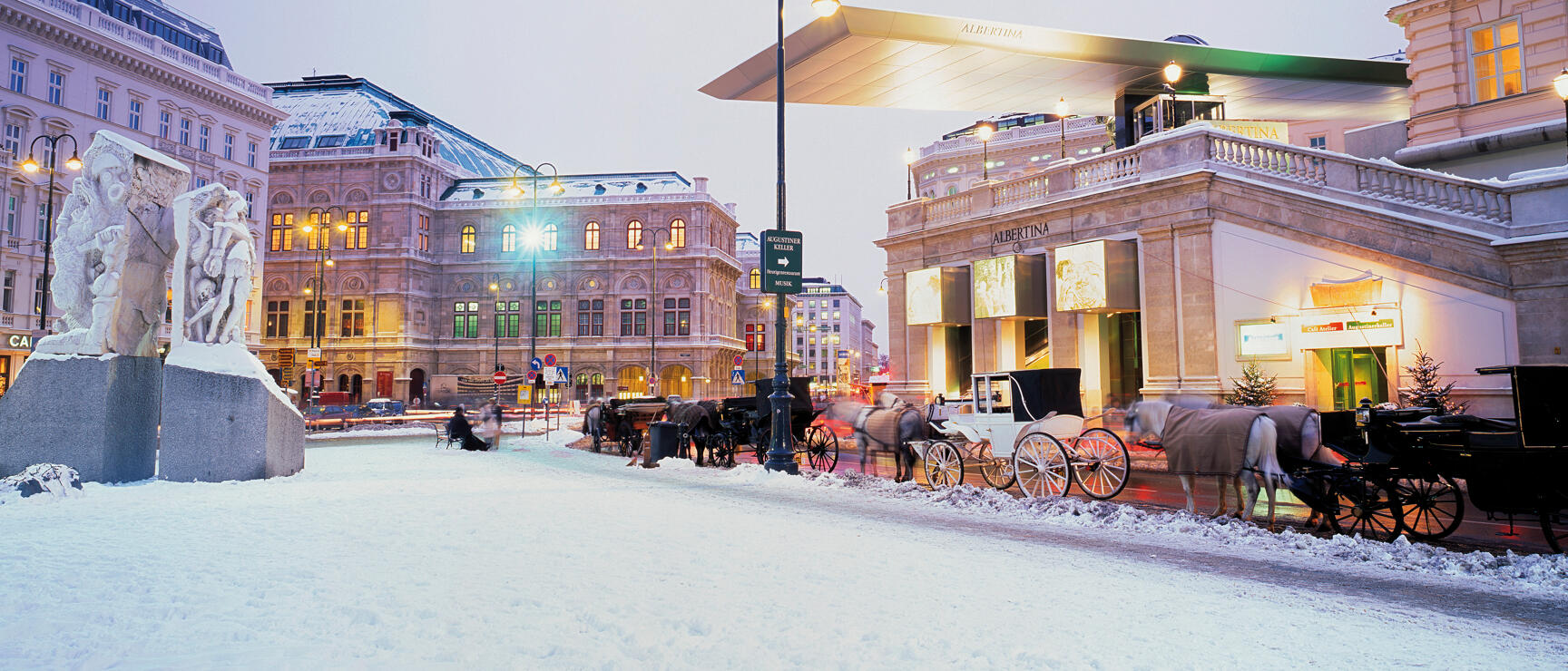 Snow-covered Albertinaplatz Vienna at dusk, fiaker, State Opera and illuminated Albertina in background