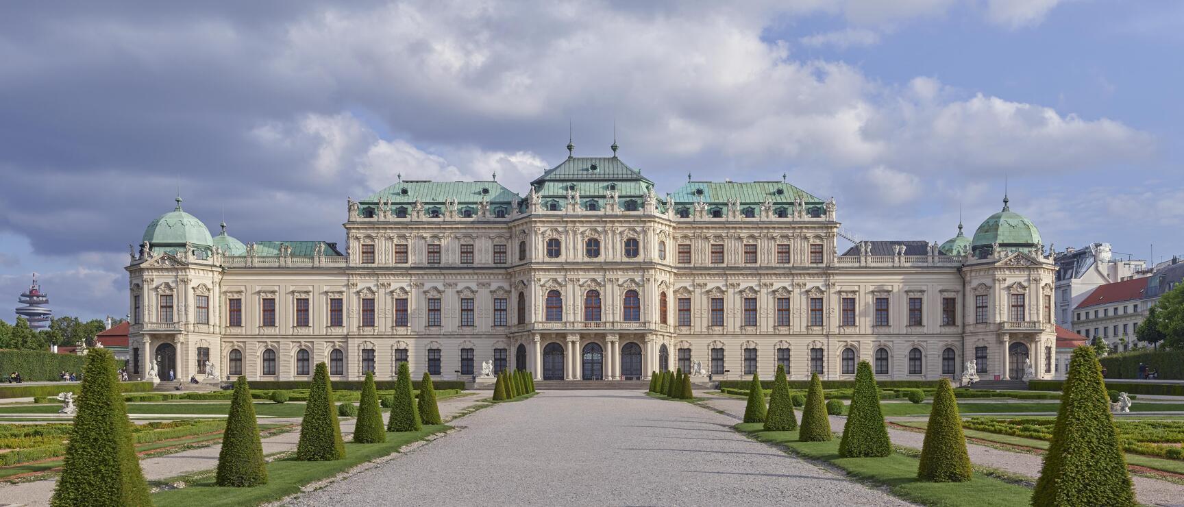 Belvedere Palace in Vienna with Baroque facade, green domes and manicured garden with conical hedges.