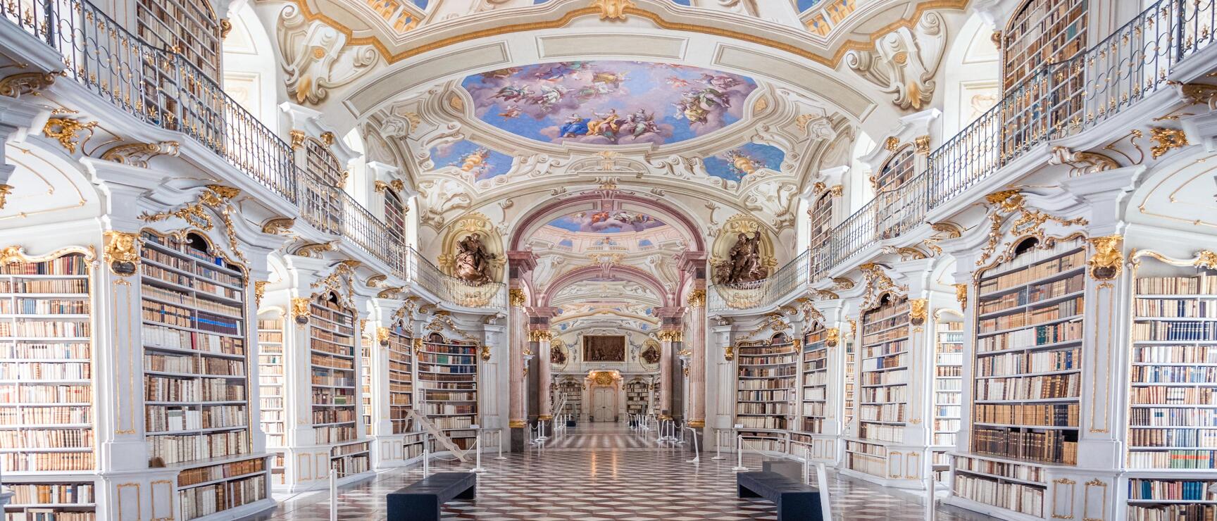 Baroque library of Admont Abbey: bookshelves, frescoed ceiling, gold decorations, marble floor.