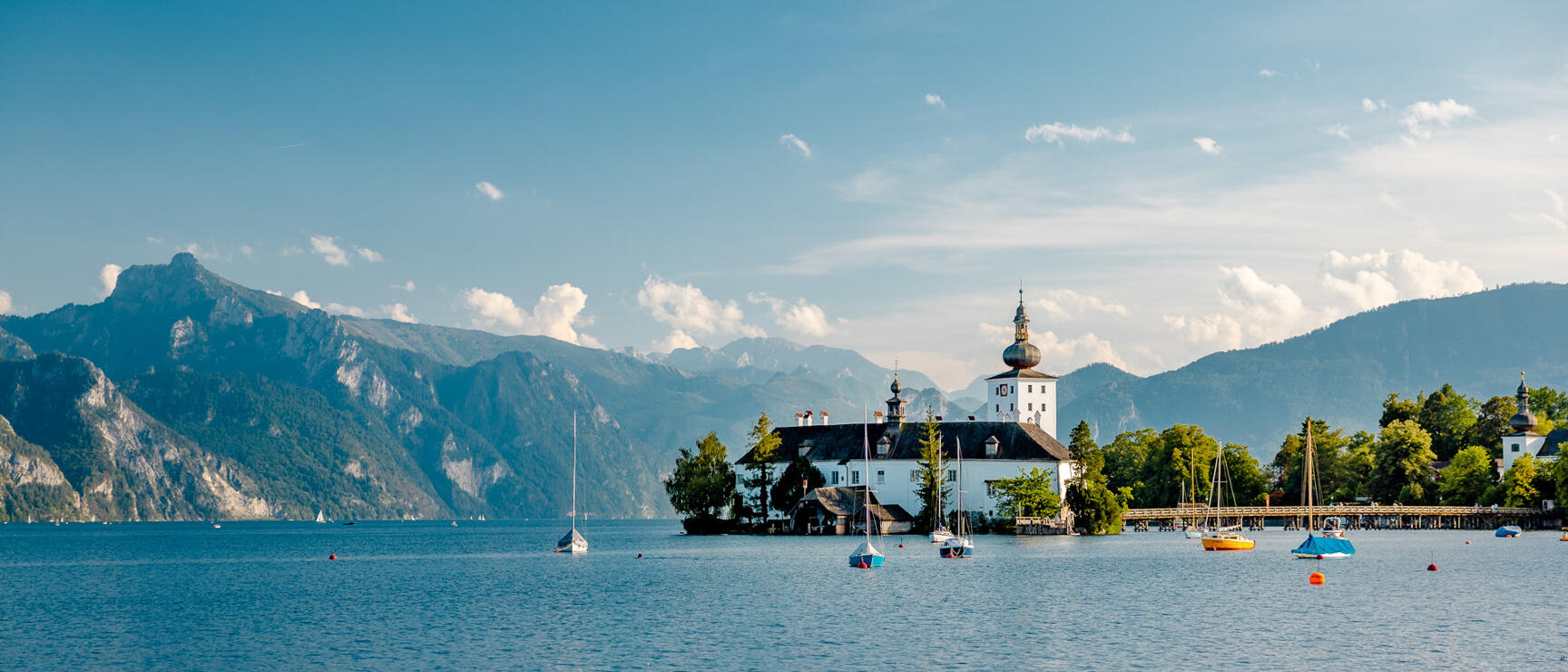 Schloss Ort castle on an island in Lake Traunsee, sailboats, mountain panorama in background, Gmunden