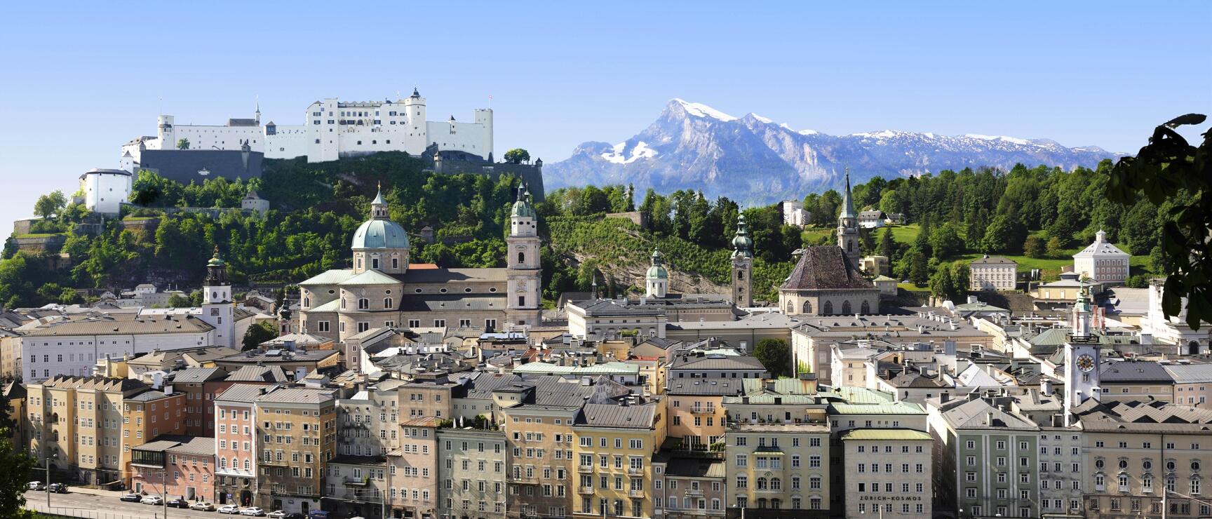 Salzburg Old Town with cathedral, Hohensalzburg Fortress and snow-capped Untersberg, Salzach River in foreground