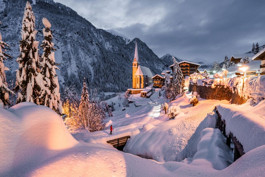 Illuminated church of Heiligenblut during winter season in the district of Spittal an der Drau in Carinthia