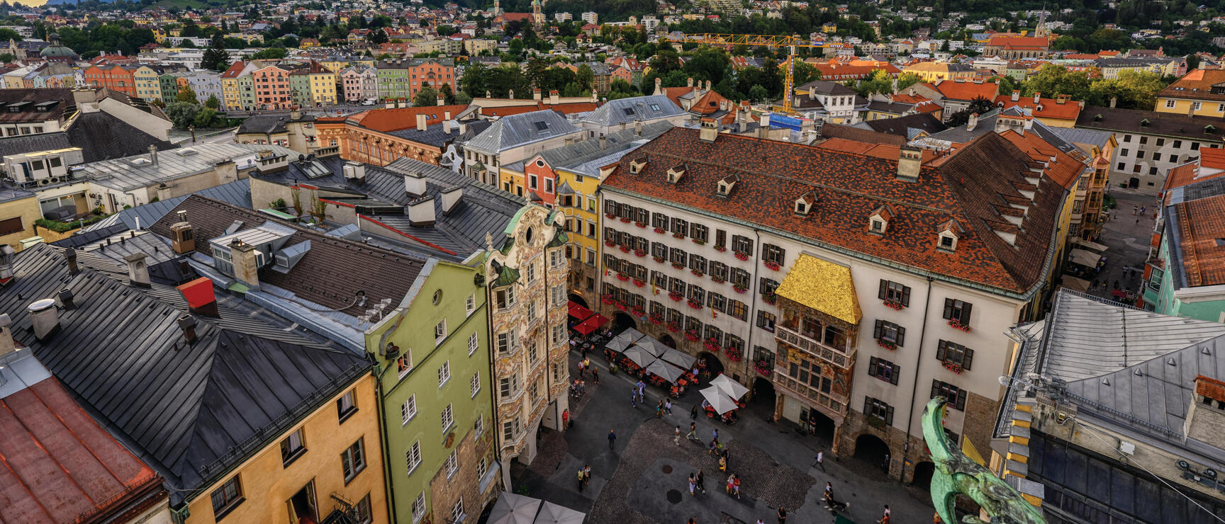 Aerial view of Innsbruck's old town with Golden Roof, colourful buildings and Karwendel mountains in evening light.