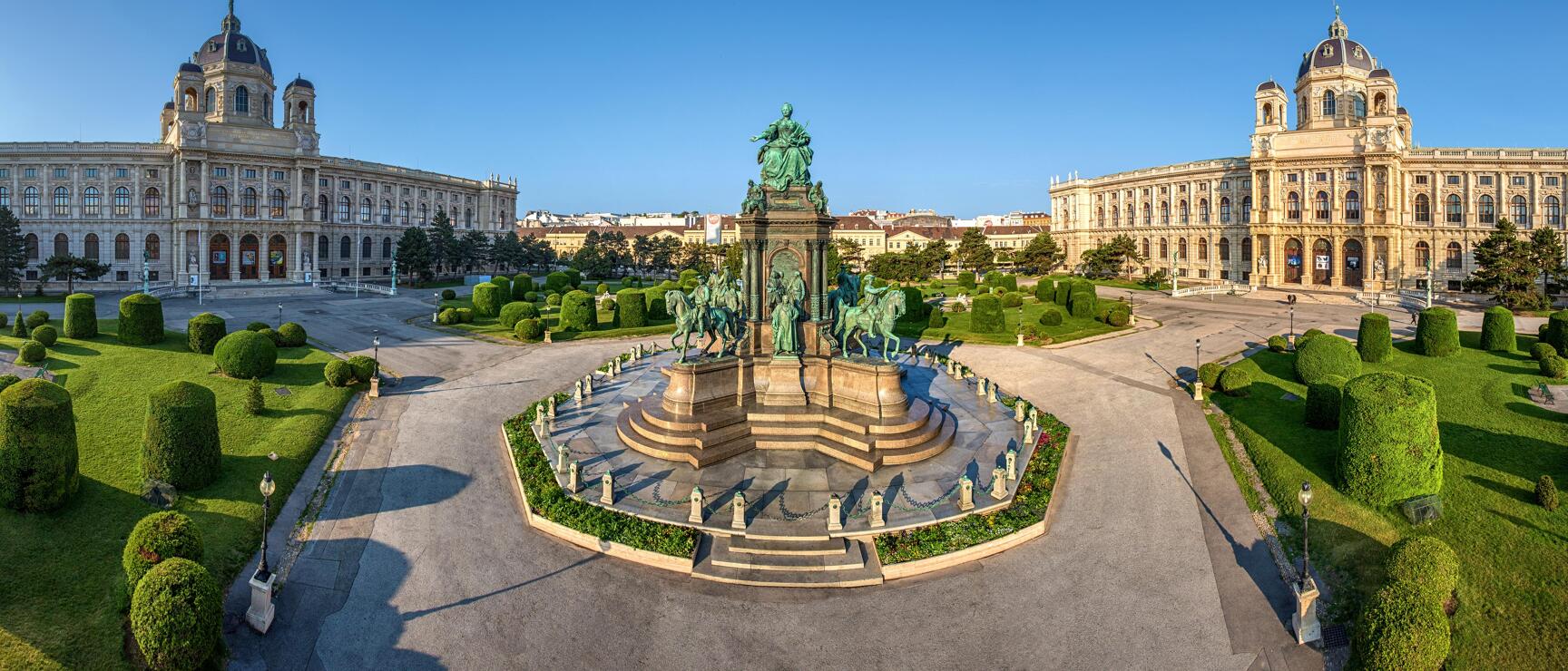Maria-Theresien-Platz Vienna: Bronze monument between Museum of Art History and Natural History Museum with manicured green spaces.