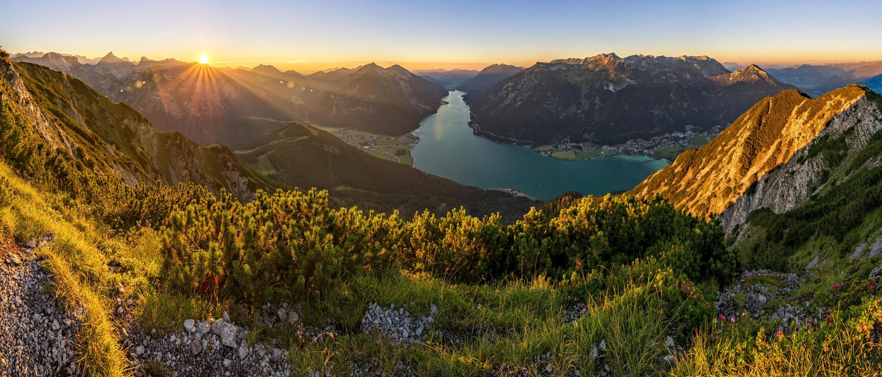 Panoramic view of Lake Achensee at sunrise, surrounded by mountains and alpine villages, Tyrol.