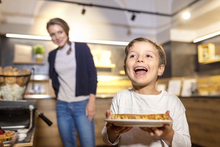 Kind mit Waffeln beim Frühstücksbuffet im JUFA Hotel