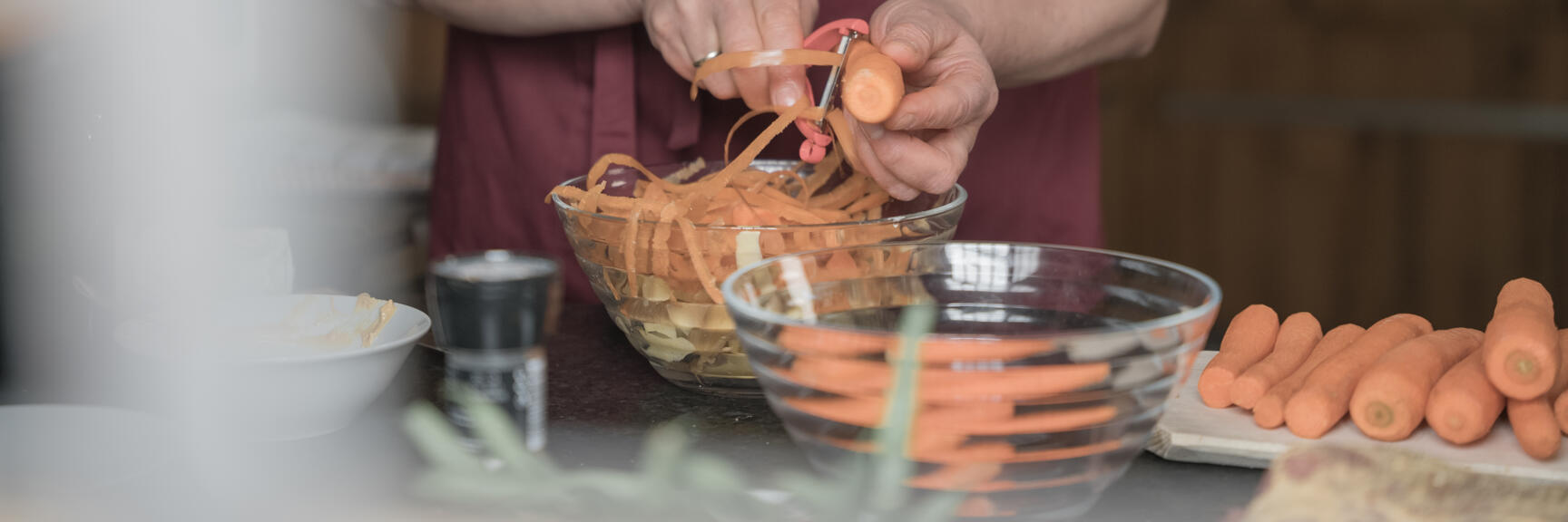 Carrots are peeled by a woman